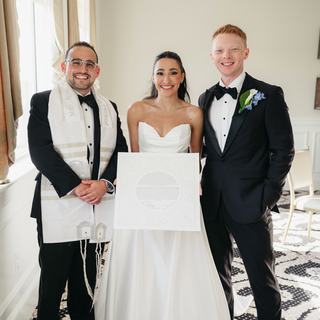 Todd Bronshtein with a newlywed couple holding their ketubah