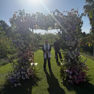 A flower-covered chuppah in a sunlit garden in Los Cabos, Mexico
